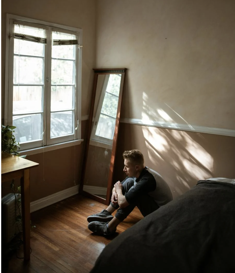 Mand sidder alene på gulvet og føler sig overvældet uden at vide hvorfor